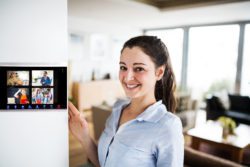 A woman looking at tablet with smart home screen.